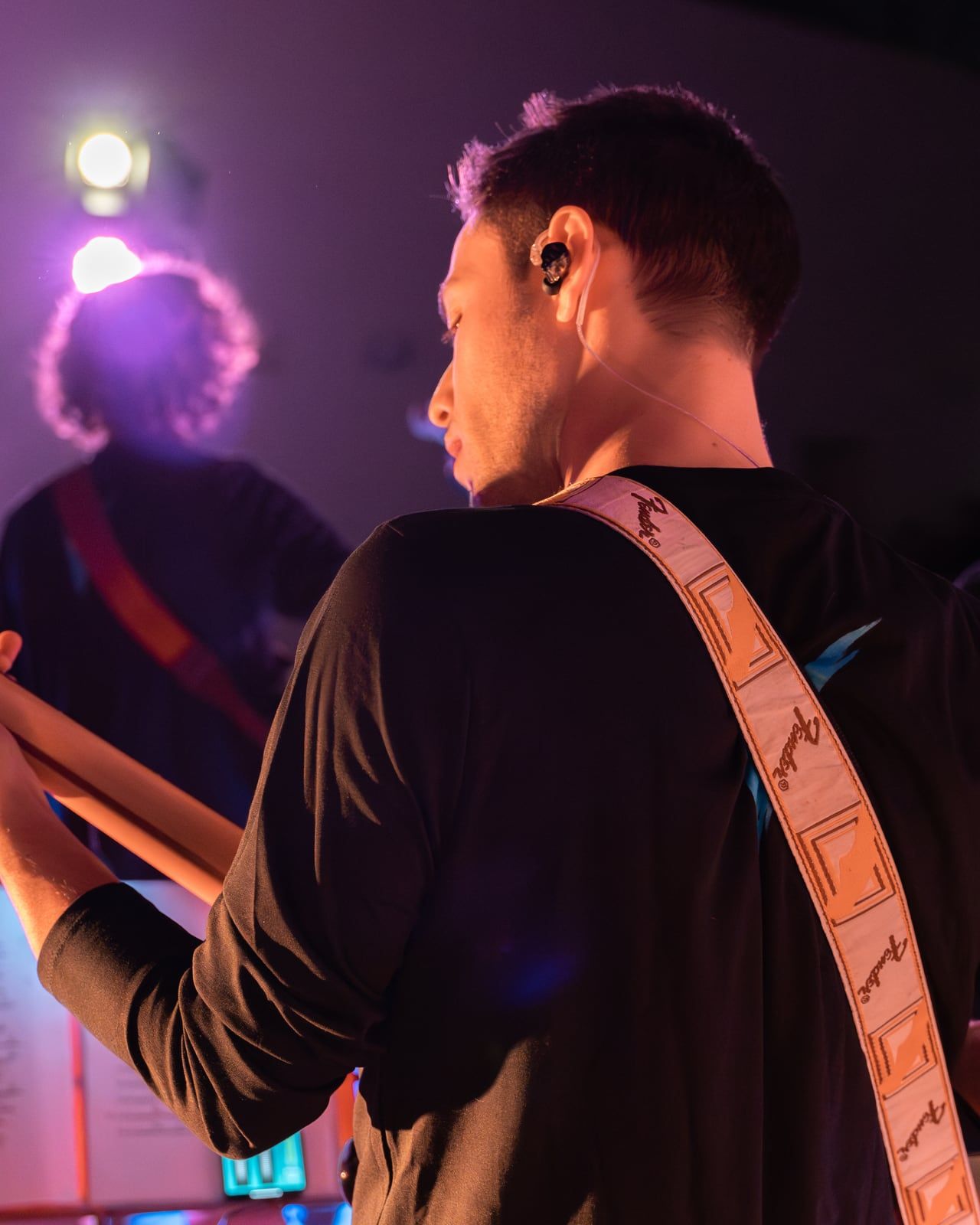Il bassista di spalle, in luce viola